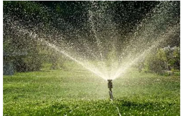 Sprinkler throwing water over a lawn, simulating rain